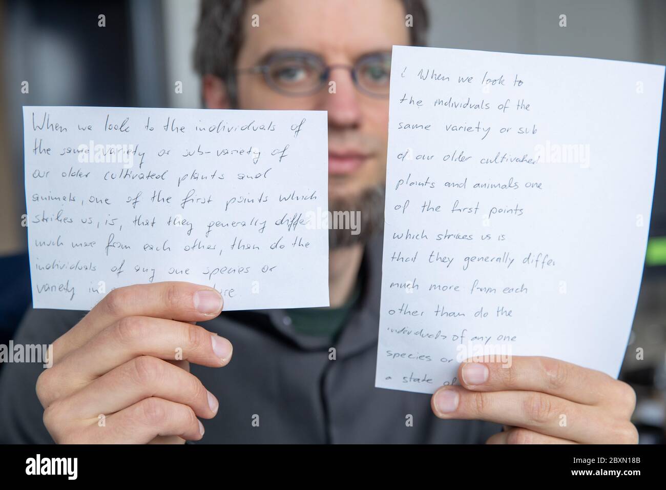 05. Juni 2020, Bayern, Erlangen: Vincent Christlein, Informatiker und wissenschaftlicher Mitarbeiter am Lehrstuhl für Mustererkennung an der Universität Erlangen-Nürnberg, hält Ausdrucke eines Mustertextes in seinen Händen. Der Text links ist handschriftlich, der Text rechts ist ein automatisch generierter Text mit dem Algorithmus zur Handschriftimitate im Stil des Originals. Erlangen-Forscher imitieren mit künstlicher Intelligenz die Handschrift. Ein Ziel ist es, Menschen zu ermöglichen, Texte in eigener Handschrift zu schreiben, die sich aufgrund von Verletzungen oder anderem ich nicht mehr selbst schreiben können Stockfoto