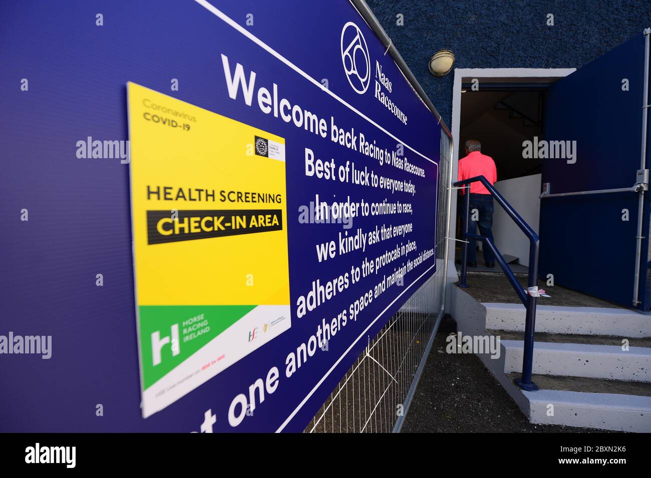 Ein Blick auf ein Gesundheits-Screening Check-in-Schild am Eingang der Naas Rennbahn, wie Rennen in Irland wieder aufgenommen heute. Stockfoto