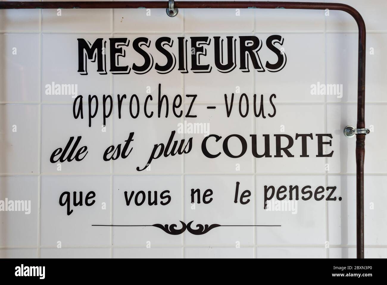 Melden Sie sich in der Herrentoilette an und bitten Sie die Benutzer, näher an Urinal, Le Vivier sur Mer, Bretagne, Frankreich, zu stehen Stockfoto