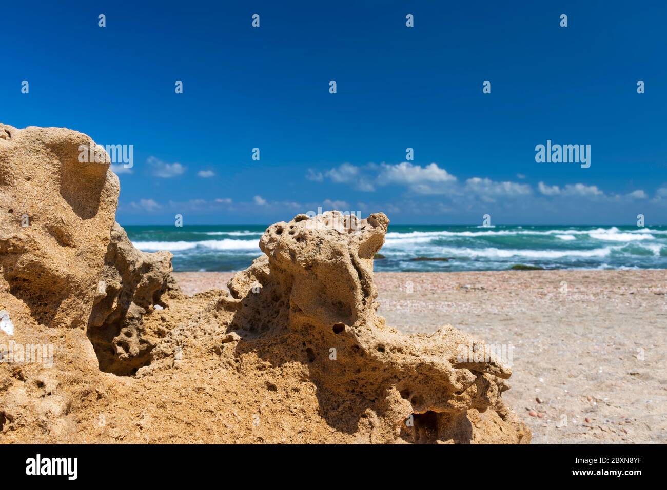 Blick auf das türkisfarbene Wasser des Mittelmeers durch Sandformationen am Ufer gegen den blauen Himmel Stockfoto