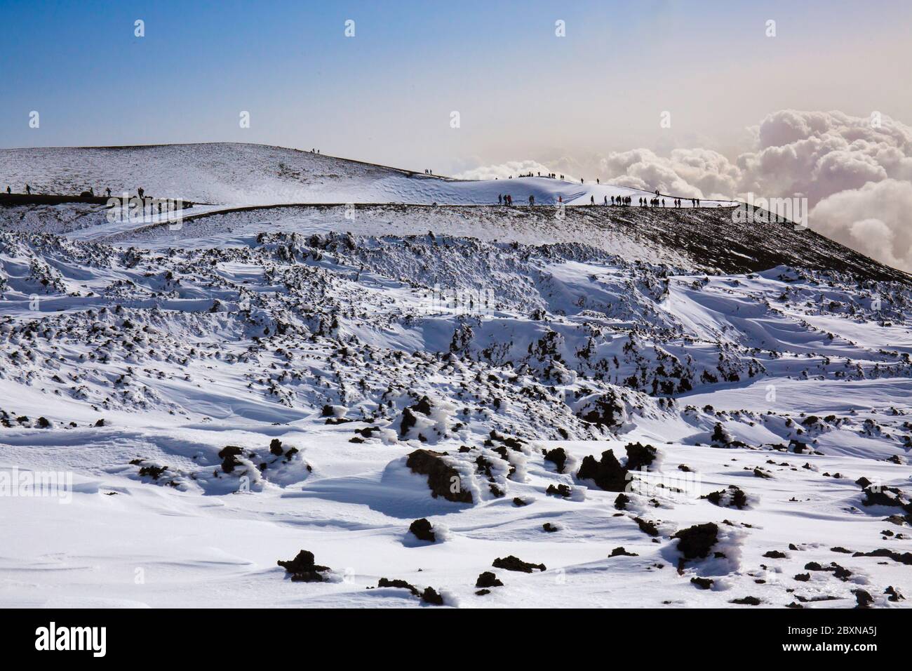 Tourist in Winterlandschaft auf dem Vulkan Ätna bei Sonnenuntergang Panoramablick auf den Barbagallo Krater; Stockfoto