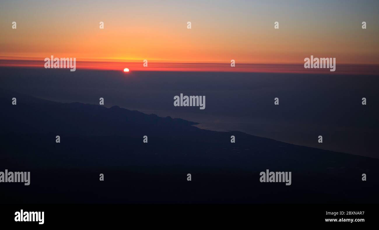 Sonnenaufgang - suggestives magentafarbenes Licht mit Wolken und dem ersten Lichttag am Himmel Stockfoto