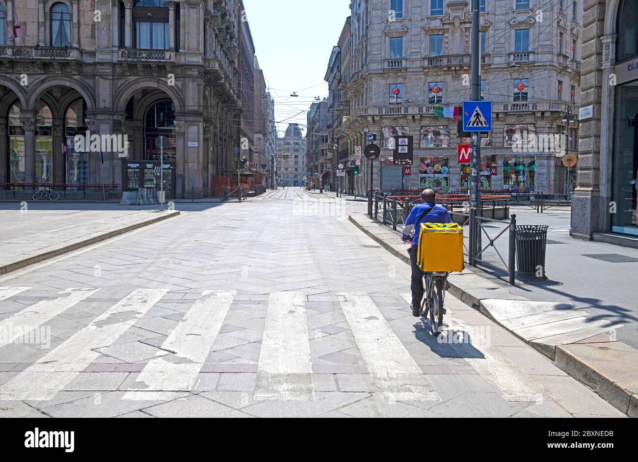 Lieferfahrer auf den leeren Straßen der Innenstadt von Mailand aufgrund der Pandemie des Covid-19, Stockfoto