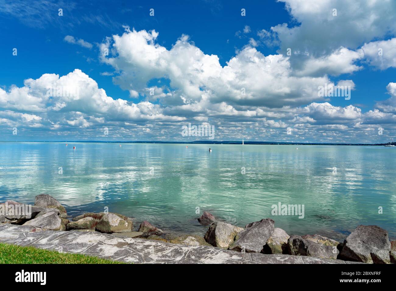 Einfaches Bild vom Plattensee in Ungarn vom Badecony Strand mit blauem Himmel und Wolkenrückbildung auf dem Wasser Stockfoto