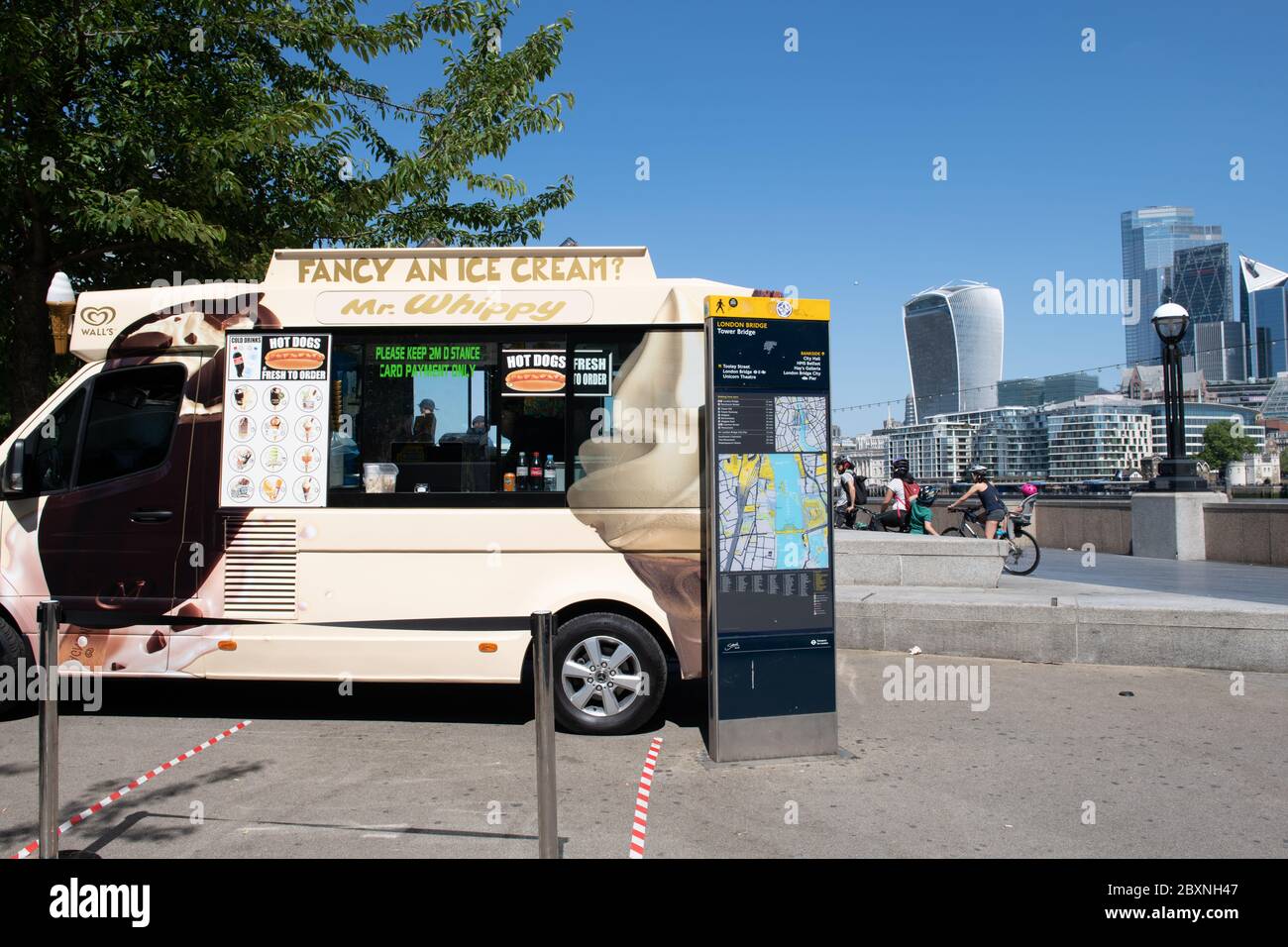 Ein Eiswagen, der an einem schönen warmen sonnigen Tag auf der South Bank mit Blick auf die City of London im Hintergrund gehandelt wird. London. GROSSBRITANNIEN. Stockfoto