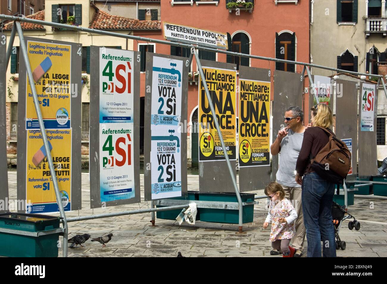 Venedig, Italien - 9. Juni 2011: Eine Familie liest politische Plakate vor den italienischen Referenden im Juni 2011 über die Atomkraft, w Stockfoto