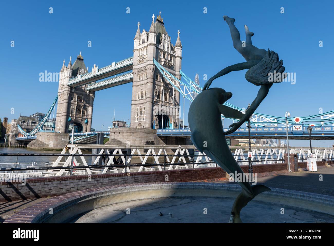 Das Mädchen mit einem Dolphin-Brunnen am Nordufer der Themse mit Blick auf die Tower Bridge an einem schönen sonnigen Frühlingstag in London. GROSSBRITANNIEN. Stockfoto