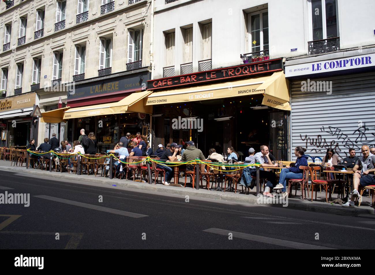 Pariser genießen einen samstagnachmittäglichen Drink auf einer sonnigen Terrasse, die nach der 19. Covid-Sperrzeit geöffnet ist - Café Bar Le Troquet, Rue de Clignancourt, 75018 Paris, Frankreich Stockfoto