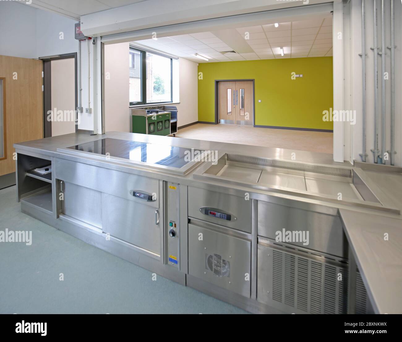 Küche in einer neu abgeschlossenen Londoner Sekundarschule. Blick über Servery in den Speisesaal. Stockfoto
