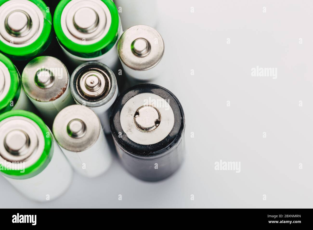 Viele neue und gebrauchte Alkali-Batterien Typ AA auf hellem Hintergrund. Stockfoto