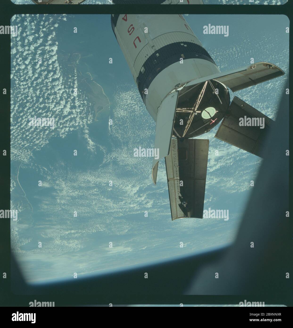 AS07-03-1543 - Apollo 7 - Apollo 7 Mission, Saturn IVB Booster während der Andockmanöver; Umfang und Inhalt: Die Originaldatenbank beschreibt dies als: Beschreibung: Apollo 7, die aufgewendete Saturn IVB-Etappe, die von der Apollo 7 Raumsonde während der Transposition und Andockmanöver fotografiert wurde. Dieses Foto wurde während der zweiten Revolution der Erde durch Apollo 7 in Pensacola und Panama City, Florida, aufgenommen. Die runde, weiße Scheibe innerhalb der offenen Panels des Saturn IVB ist ein simuliertes Andockziel, ähnlich dem, das auf dem Mondmodul für das Andocken während Mondmissionen verwendet wird. Hoch schräg. Wolken Stockfoto