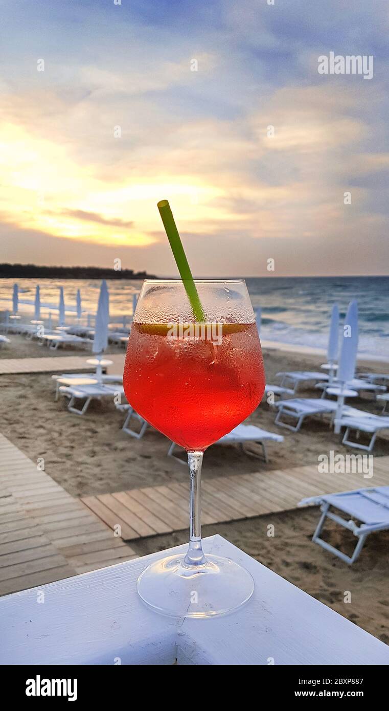 Cocktail Aperol Spritz auf dem Hintergrund des Strandes mit Liegestühlen  und Sonnenschirmen, Apulien, Italien Stockfotografie - Alamy