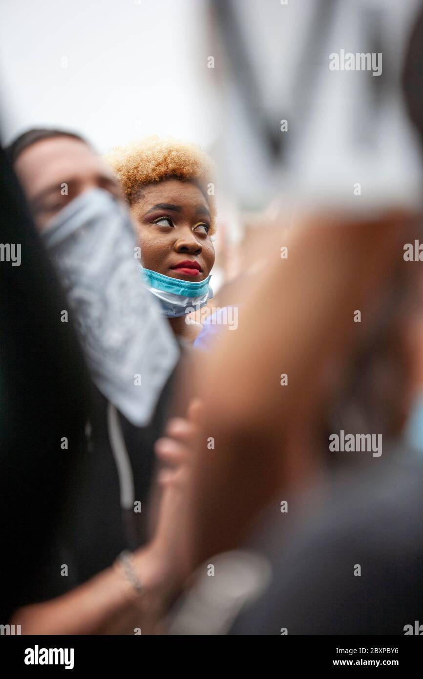 Frau mit einer kurzen, blonden Afro-Frisur und Gesichtsmaske steht in einem überfüllten Hyde Park für den BLM UK Protest. London, Großbritannien Stockfoto