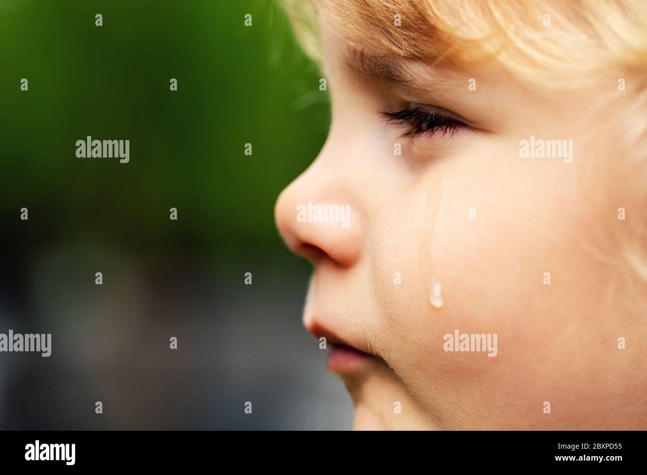 Weinendes trauriges Kind - kleines Mädchen Gesicht mit Träne auf der Wange. Konzept der Kinderrechte und Missbrauch Stockfoto