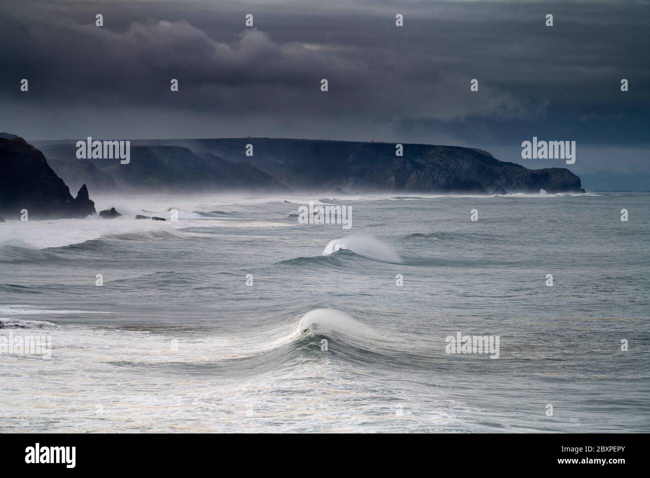 Malerischer Blick auf die Küste entlang des Amado-Strandes (Praia do Amado) mit großen Wellen während eines Sturms an der Algarve, Portugal Stockfoto