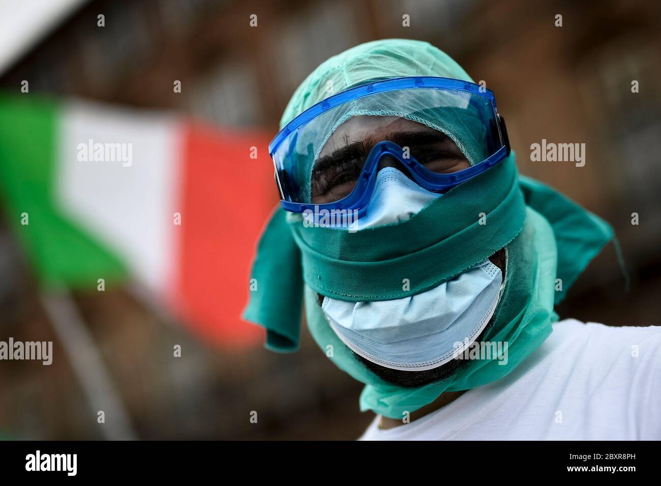 Turin, Italien - 08. Juni 2020: Eine geknebelt Krankenschwester schaut zu, während eine italienische Flagge im Hintergrund während eines Flash Mob Protestes von der Gewerkschaft Nursing Up organisiert. Demonstranten forderten bessere Vertragsbedingungen und riefen die Namen von Kollegen zurück, die wegen des COVID-10-Coronavirus starben. Quelle: Nicolò Campo/Alamy Live News Stockfoto