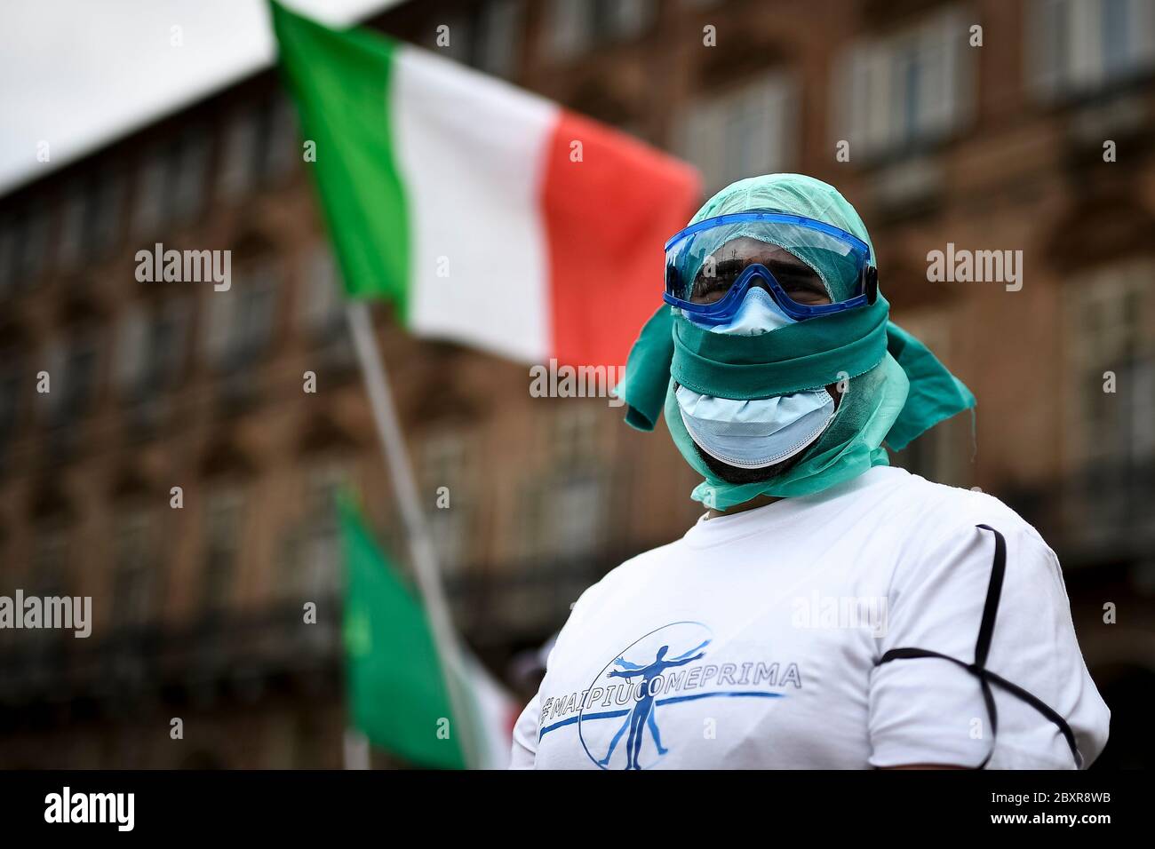 Turin, Italien - 08. Juni 2020: Eine geknebelt Krankenschwester schaut zu, während eine italienische Flagge im Hintergrund während eines Flash Mob Protestes von der Gewerkschaft Nursing Up organisiert. Demonstranten forderten bessere Vertragsbedingungen und riefen die Namen von Kollegen zurück, die wegen des COVID-10-Coronavirus starben. Quelle: Nicolò Campo/Alamy Live News Stockfoto