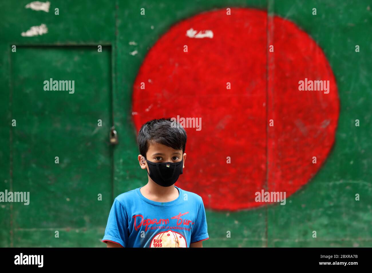 Dhaka, Bangladesch. Juni 2020. Ein Junge, der als vorbeugende Maßnahme eine Gesichtsmaske trägt, geht während der Coronavirus-Pandemie auf die Straße.42 Menschen sind in den letzten 24 Stunden an Coronavirus-Infektionen gestorben, sagte die Generaldirektion Gesundheitsdienste (DGHS) heute. Zweitausend siebenhundertsechzig Menschen haben in den letzten 24 Stunden positiv auf Covid-19 getestet. Damit hat die Gesamtzahl der Infizierten 68,504 erreicht. Quelle: SOPA Images Limited/Alamy Live News Stockfoto