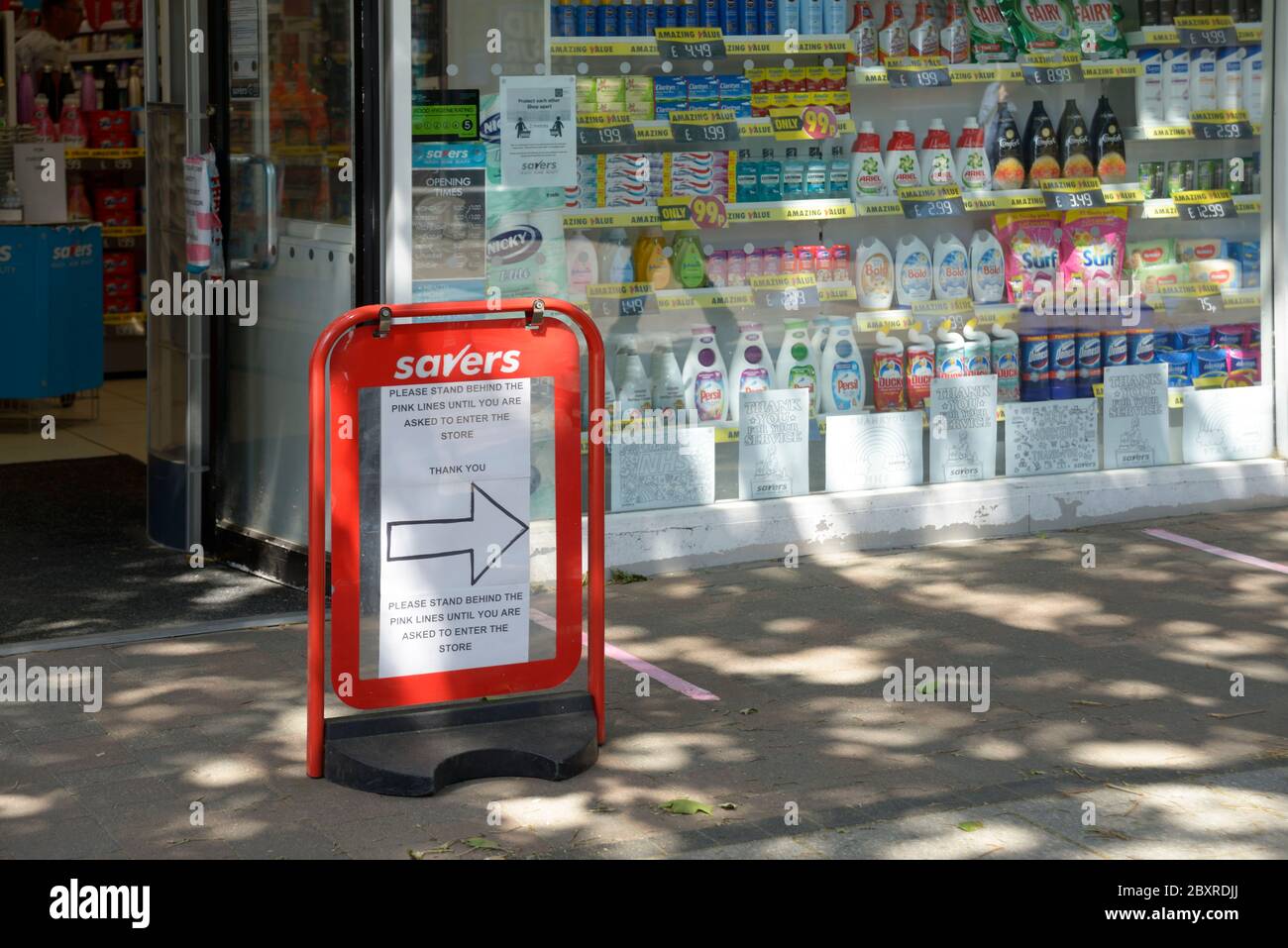 Schild, das den Leuten während des Corona Virus Ausbruchs vor dem Geschäft aufzeigt. Stockfoto