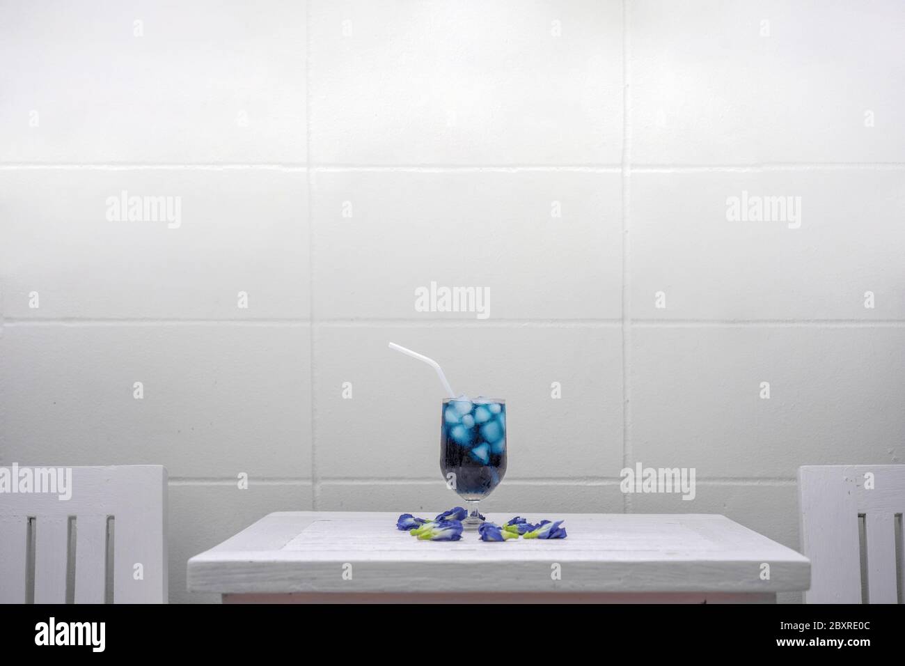 Schmetterlingserbsenauf einem pastellrosa Holztisch vor der Zementwand auf dem Außenfeld. Stockfoto