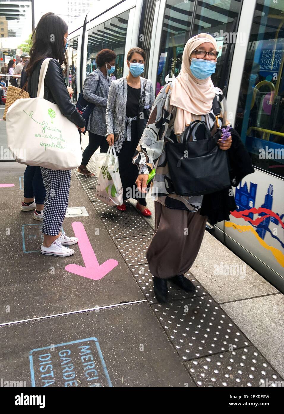 Maskierte Personen und Sicherheitsvorschriften an einem Straßenbahnbahnhof in Lyon, Frankreich Stockfoto