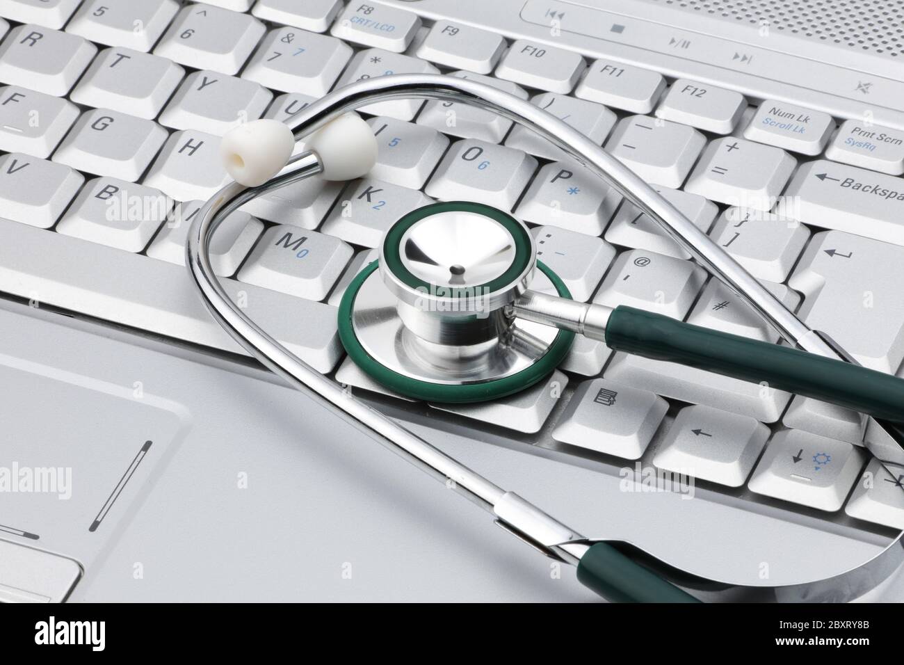 Medizinisches Stethoskop auf einem Laptop, das die Beziehung VON IT und Medizin darstellt Stockfoto