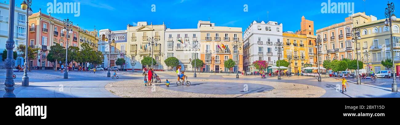 CADIZ, SPANIEN - 23. SEPTEMBER 2019: Panorama des Plaza de San Antonio mit dichten Gebäuden, getrimmten Bäumen und alten Straßenlaternen, im September Stockfoto