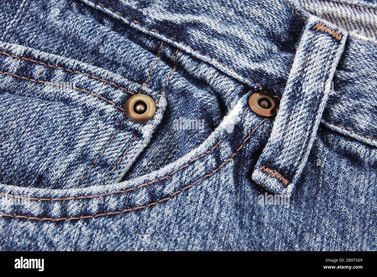 Blaue Jeans Nahaufnahme Detail zeigt Fronttasche und Taille sowie Gürtelschlaufe und Nieten Stockfoto