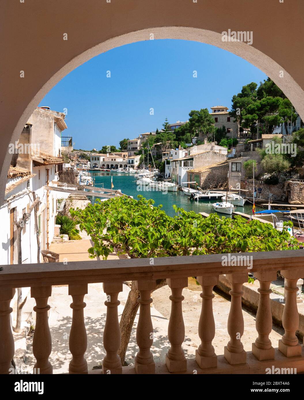 Cala Figuera Hafenblick von Ferienvilla Terrasse Terrasse Bogen durch Fischerboote Häuser und Villen, Mallorca Balearen Spanien eingerahmt Stockfoto