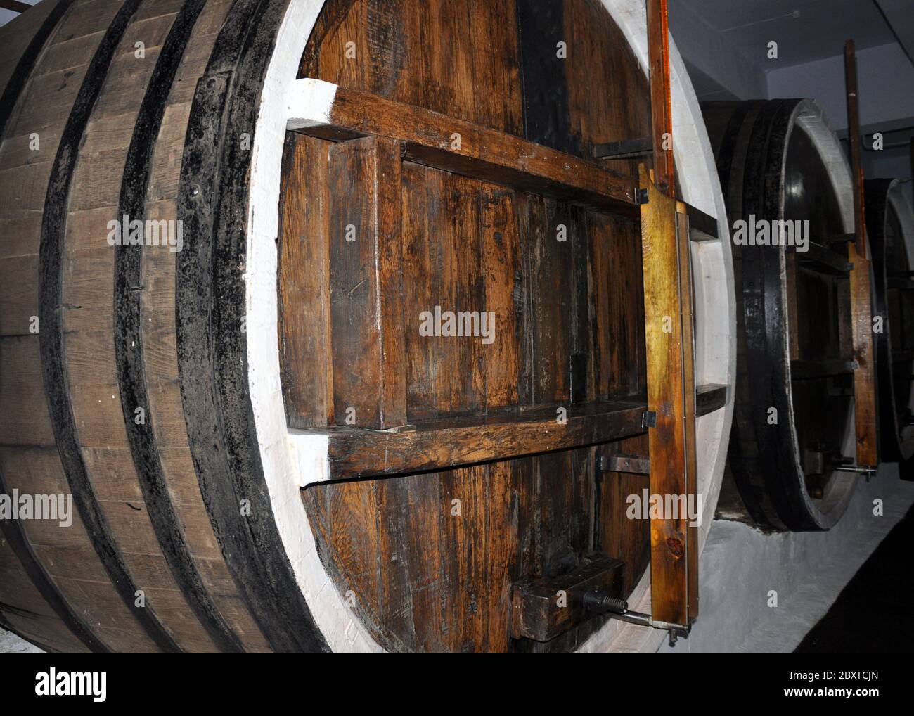 Reihen von Alkoholfässern in einem Lager einer Fabrik für die Produktion von Cognac, Whiskey, Wein, Brandy. Stockfoto