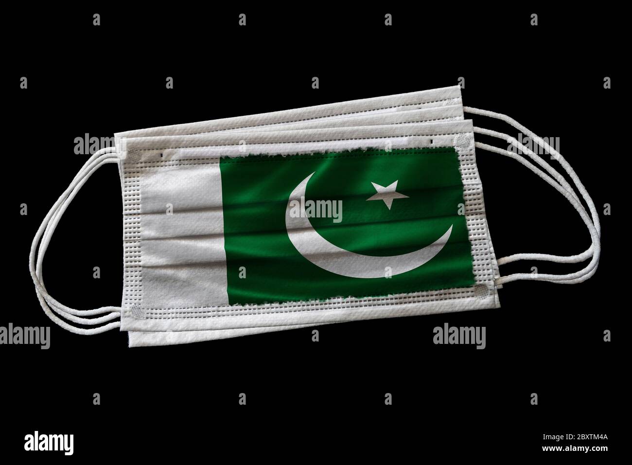 Chirurgische Gesichtsmasken mit Flagge von Pakistan gedruckt. Isoliert auf schwarzem Hintergrund. Konzept der Gesichtsmaske Verwendung in der pakistanischen Bemühungen, Covid-19 zu bekämpfen Stockfoto