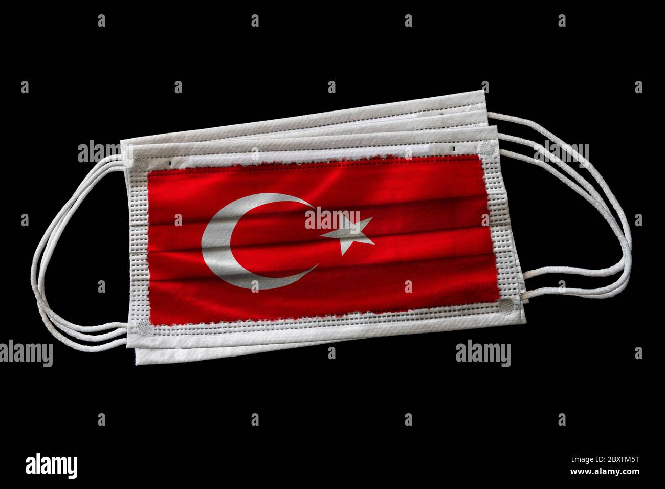 Chirurgische Gesichtsmasken mit Flagge der Türkei gedruckt. Isoliert auf schwarzem Hintergrund. Konzept der Gesichtsmaske Verwendung in der türkischen Bemühungen zur Bekämpfung Covid-19 cor Stockfoto