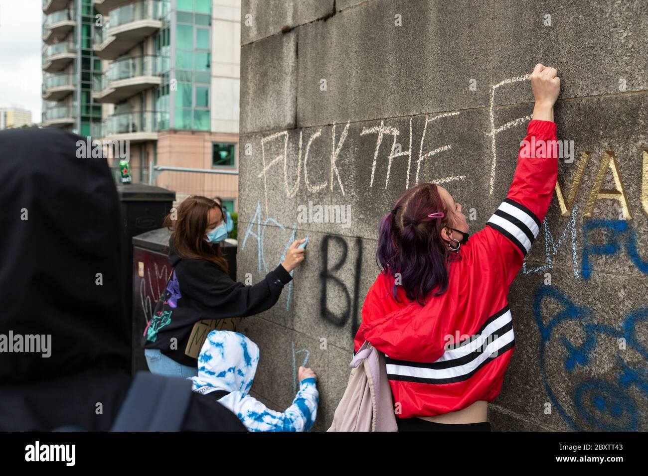 Zwei junge Mädchen kratzen Graffiti mit Kreide auf der Vauxhall Bridge während des Black Lives Matters Protests in London, 6. Juni 2020 Stockfoto