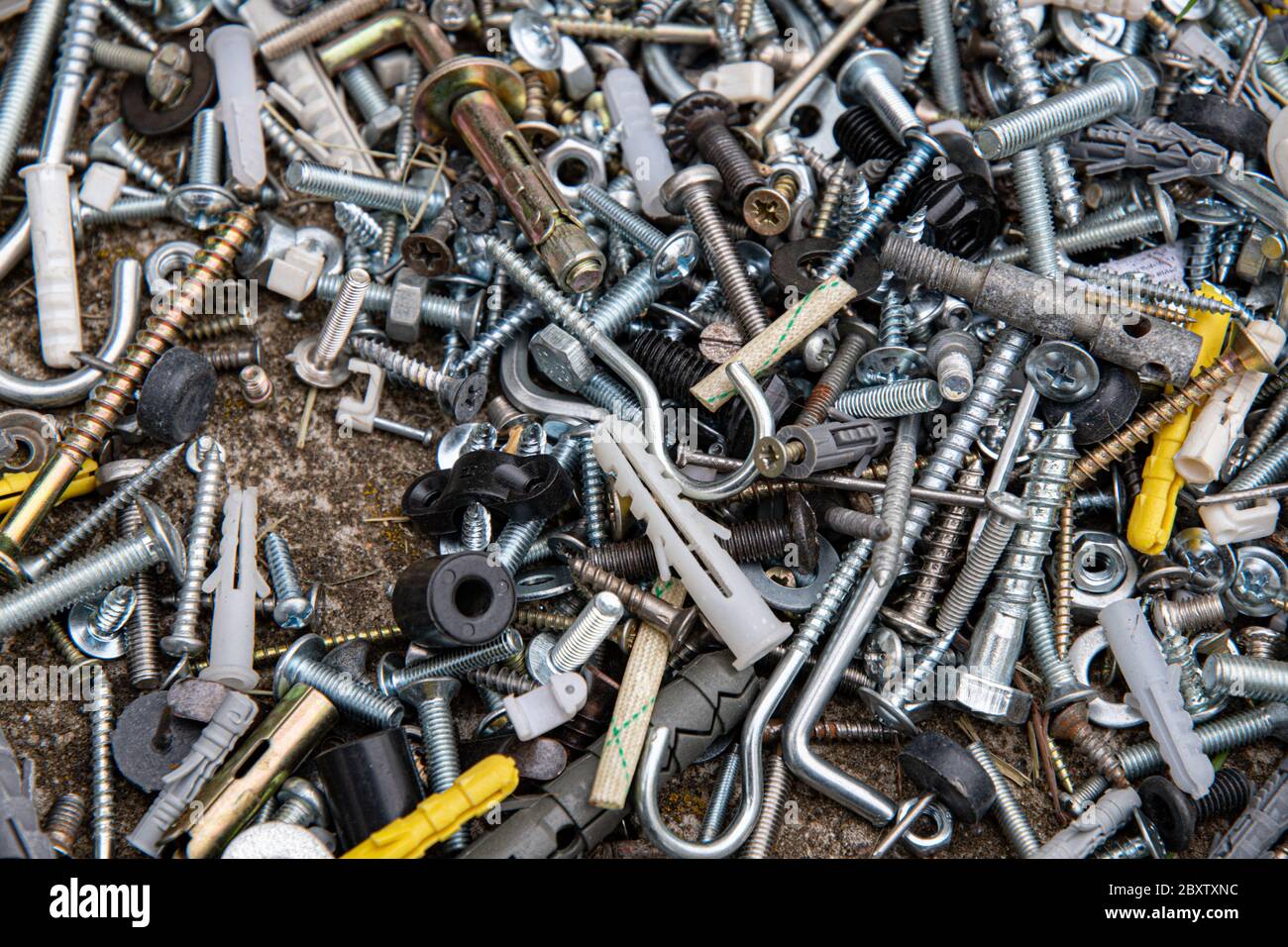 Viele verschiedene Befestigungsschrauben und Muttern flach legen. Metallwerkzeuge Nahaufnahme. Abstrakter industrieller Hintergrund für Vatertag Stockfoto