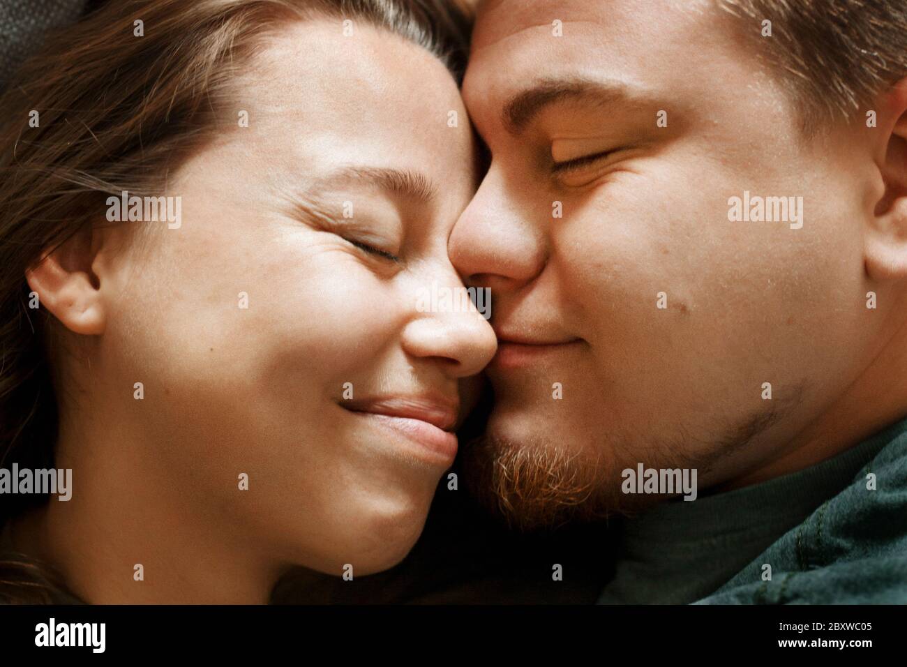 Emotionales Porträt von liebevollem lächelndem küssendem Paar, Nahaufnahme. Junge liebevolle Freund und Freundin, echte Menschen. Stockfoto