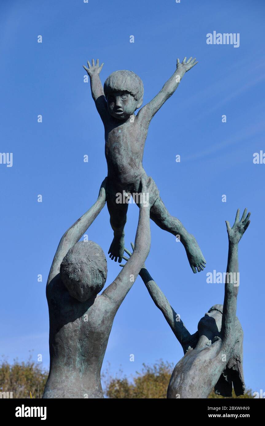 Eine Bronzeskulptur von David Wynne, in der drei Kinder in den Gärten der Tresco Abbey auf der Insel Tresco spielen.Isles of Scilly.Cornwall Stockfoto