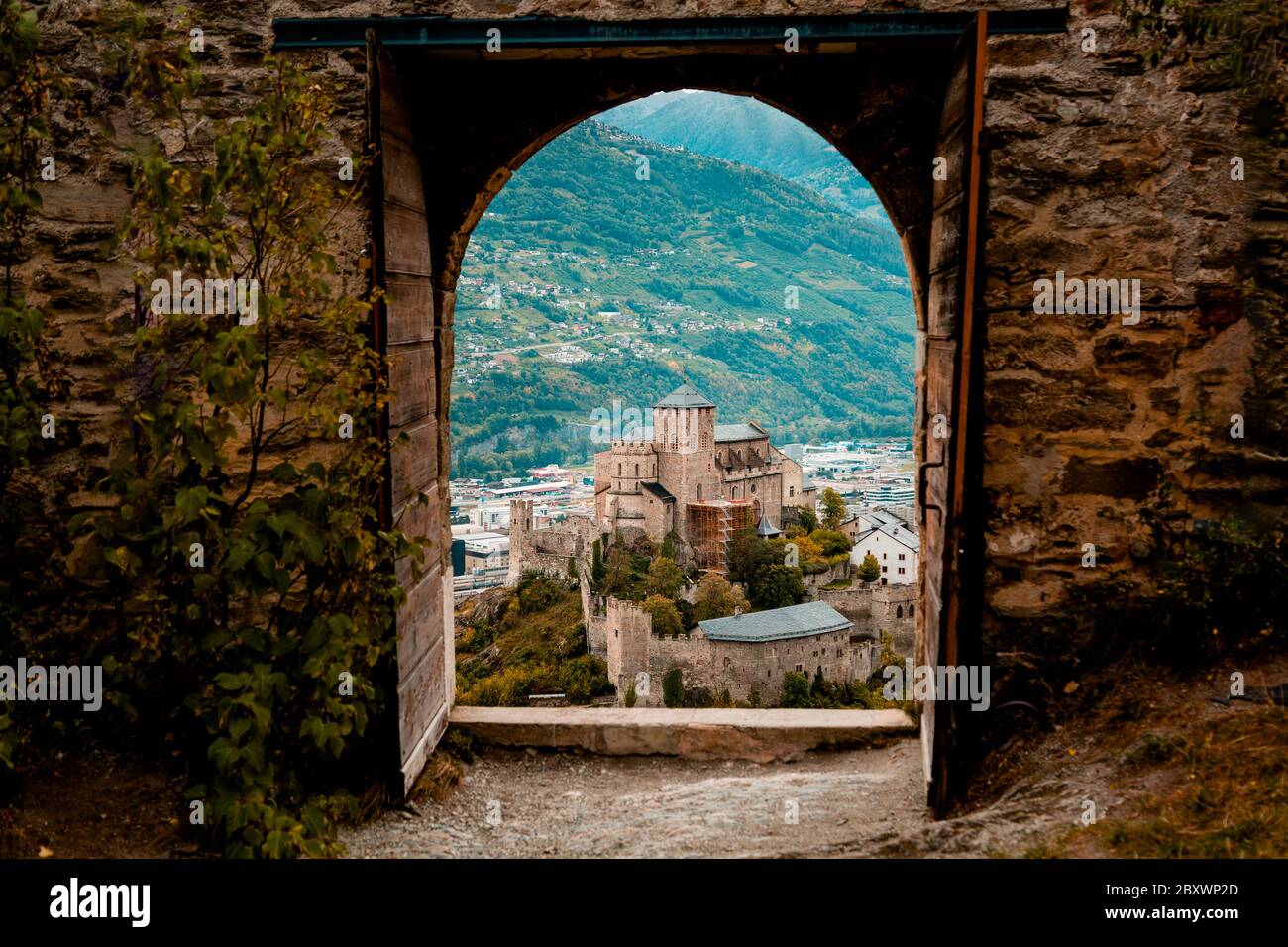 Sion, Schweiz: Mittelalterliche Basilika Valere durch die Haupttore des Schlosses Tourbillon im Kanton Wallis gesehen Stockfoto