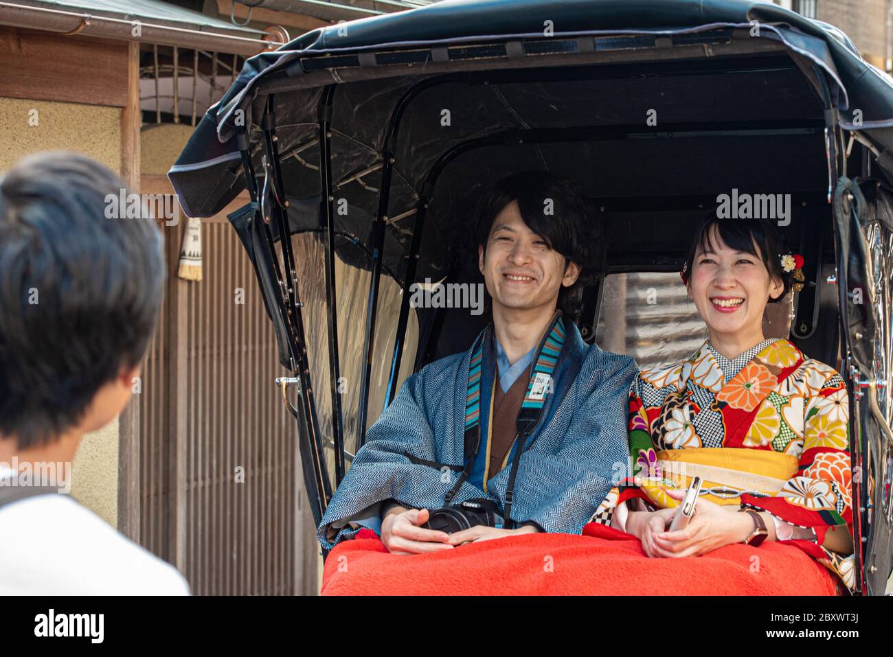 Ein junges japanisches Paar genießt eine Fahrt auf einem Rikscha in der Altstadt von Gion, kyoto, Japan Stockfoto