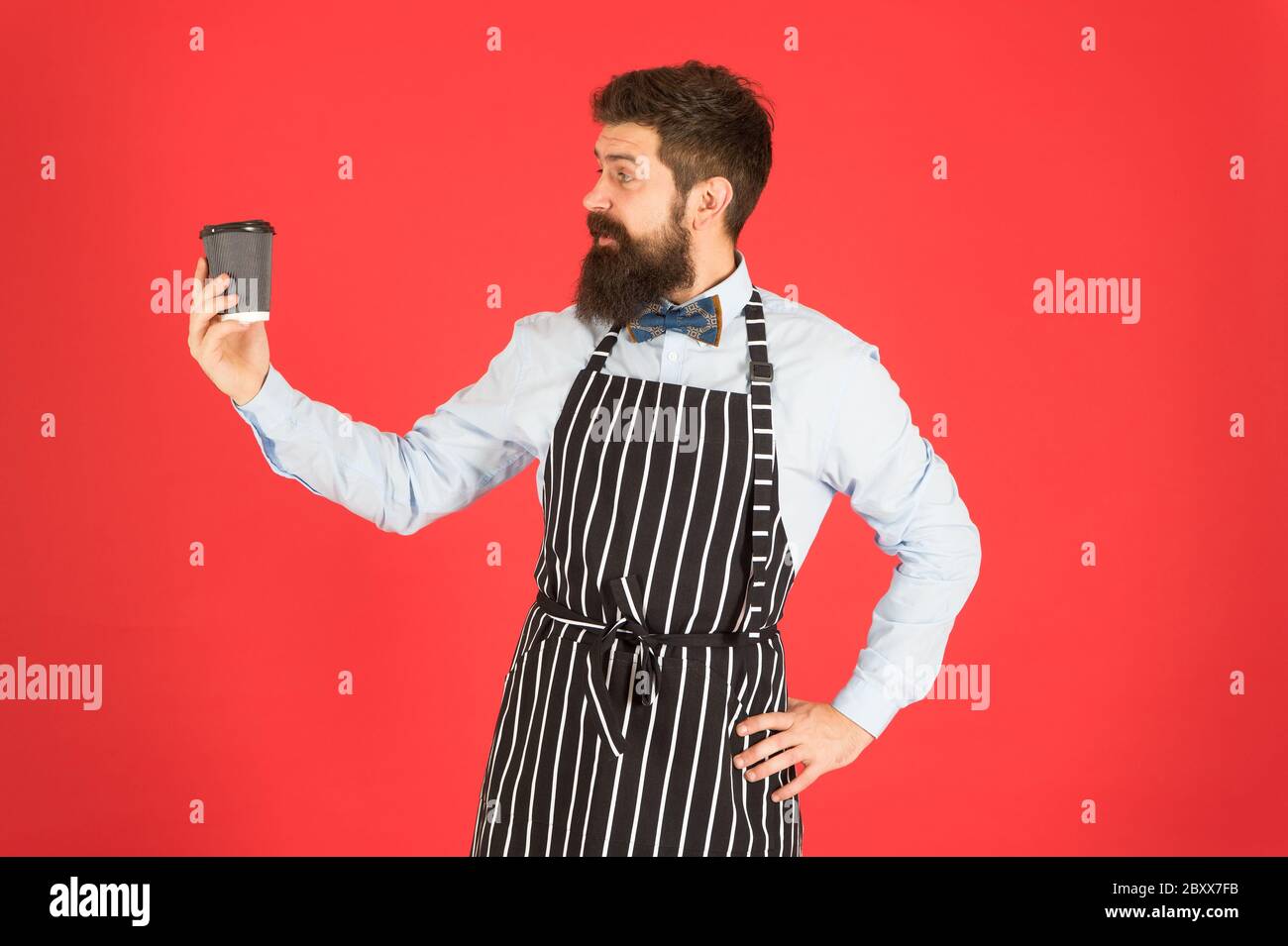 Brutale Kaffeemaschine. Porträt von bärtigen Barista stehen im Café. Barista gutaussehende Arbeiter. Freundliche Barista geben große Latte. Professionelle Kellner oder Barkeeper servieren Kaffee. Stockfoto