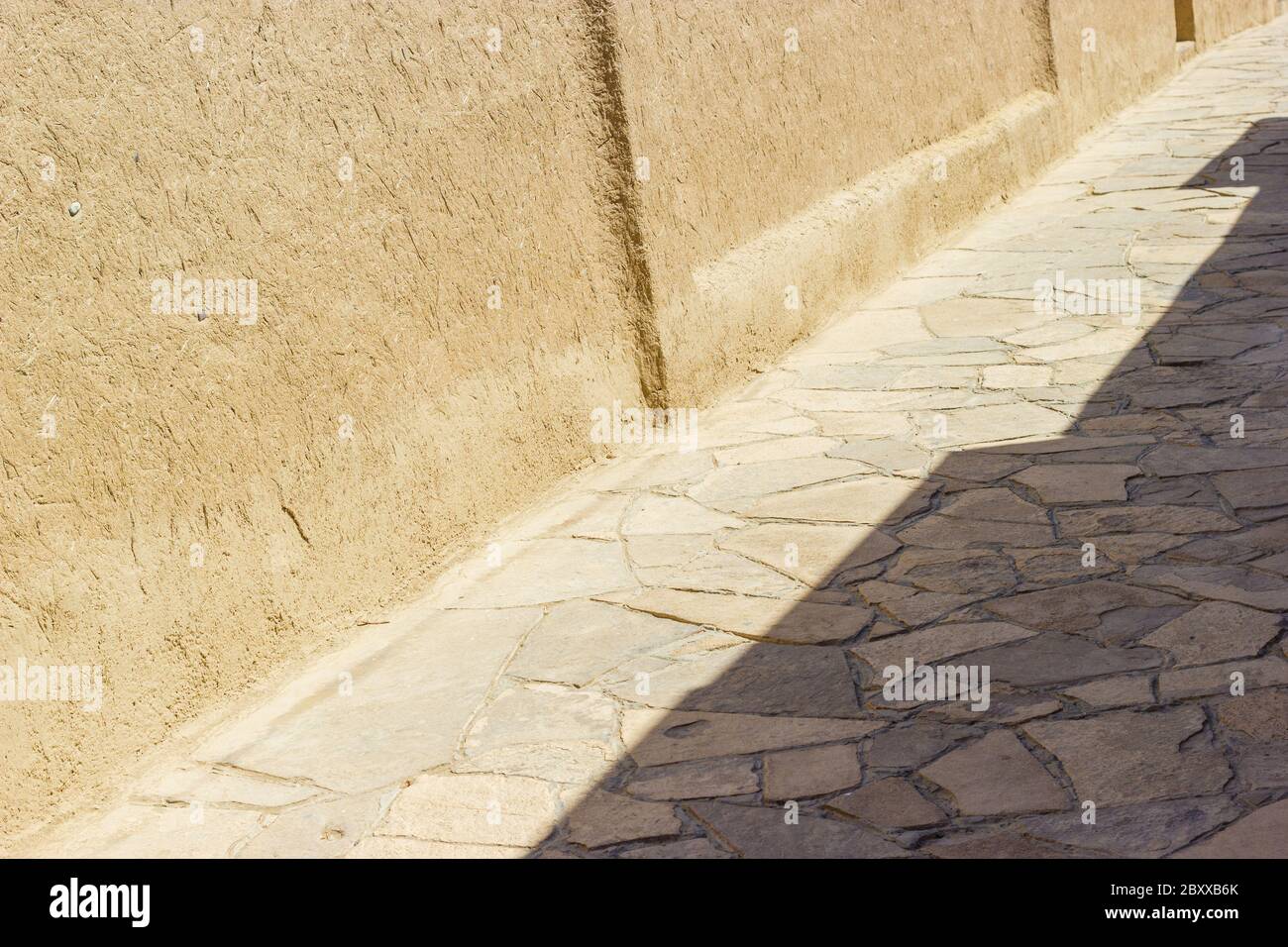 Alte Straße Hintergrund mit adobe Material Wände und Pflastersteine. Naher Osten oder zentralasiatische ländliche alte Land Stockfoto