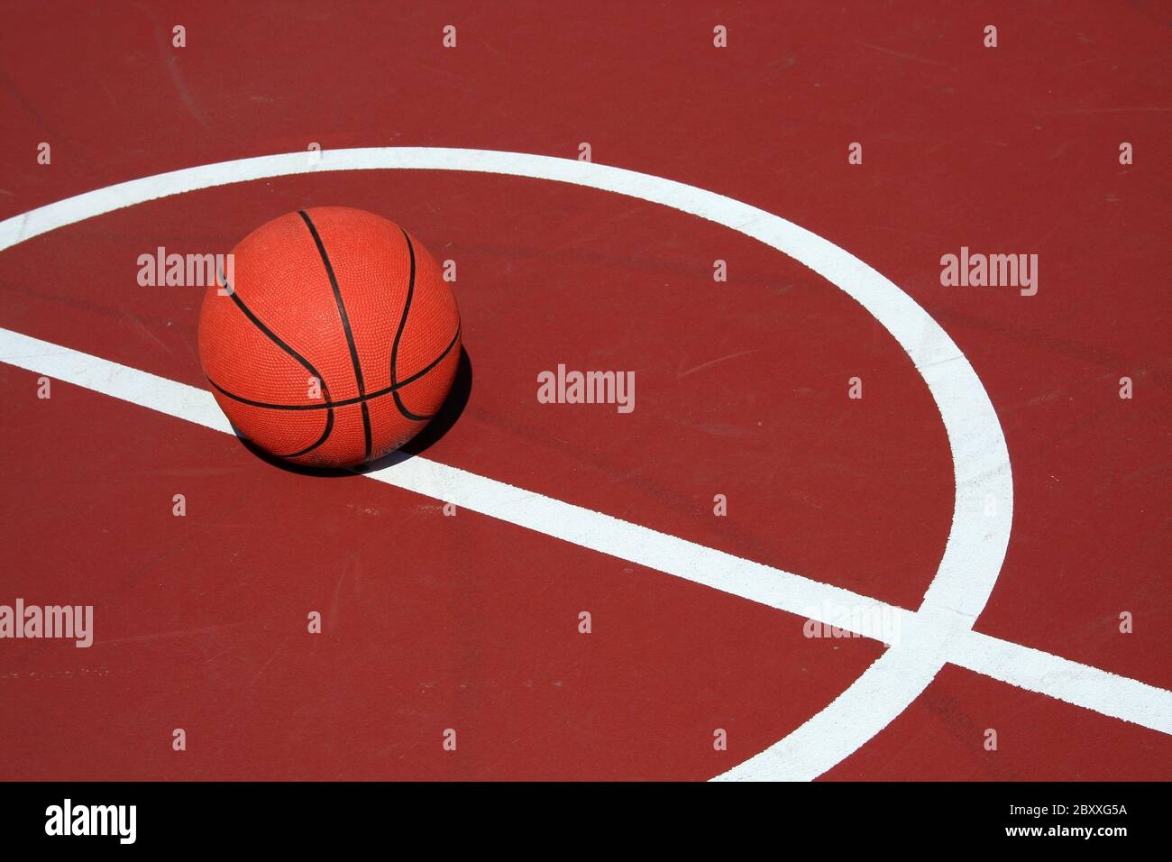 Ein Basketball am Center Court auf einem roten Hof Stockfoto