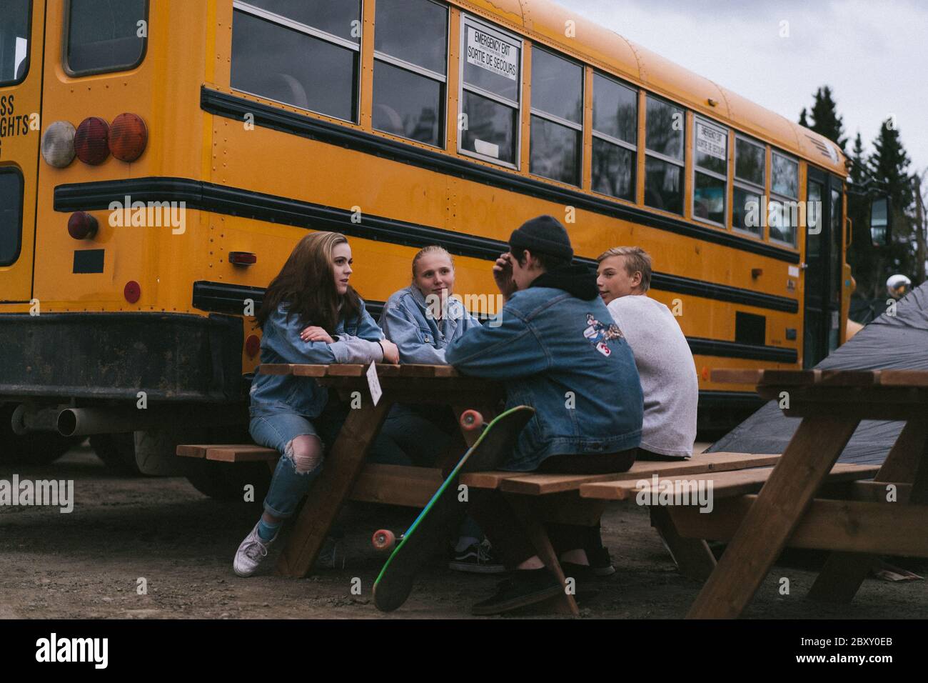 Kinder hängen mit dem Schulbus herum Stockfoto