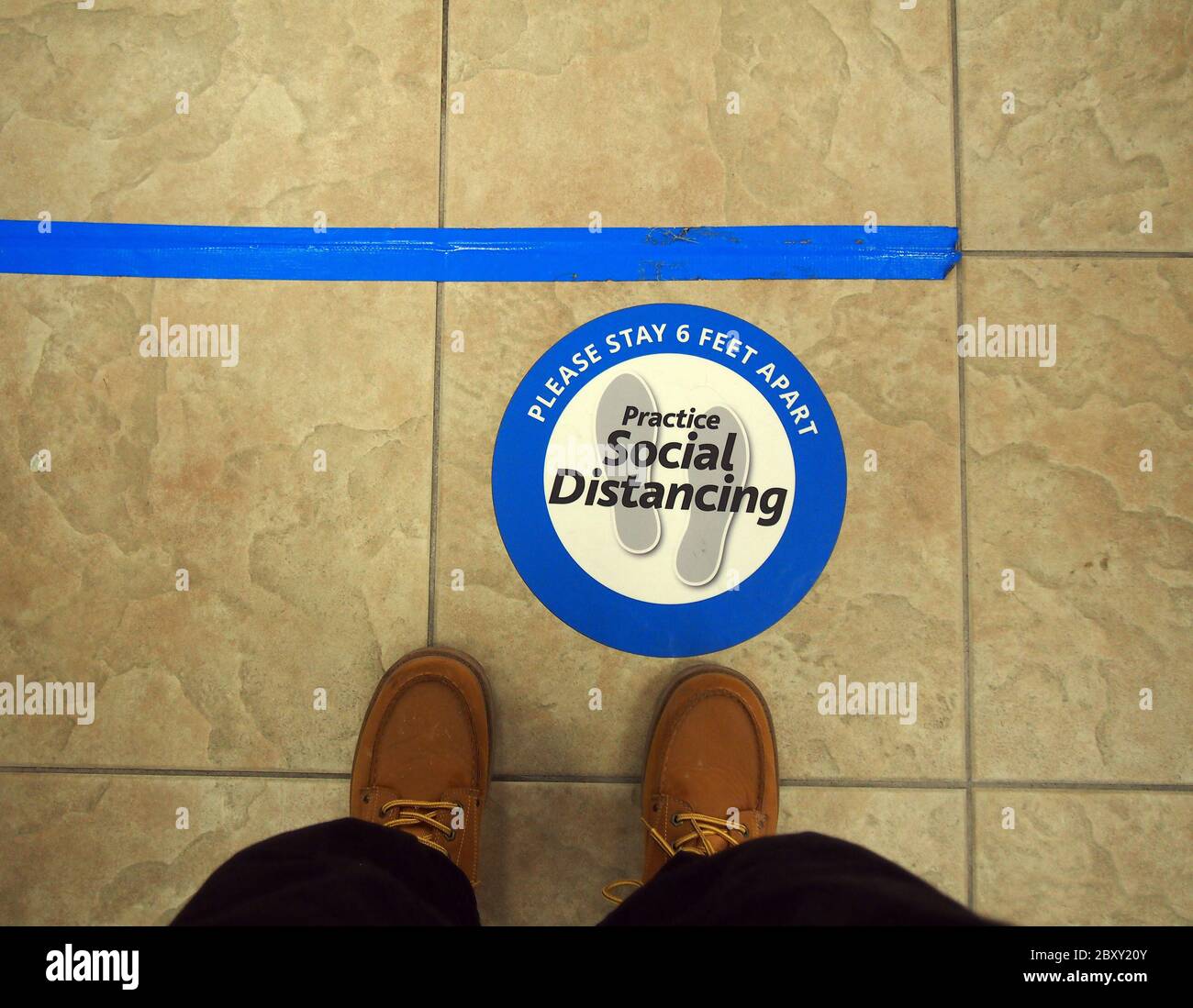 Üben Sie soziale Distanz und bitte bleiben 6 Fuß auseinander Marker auf dem Boden einer Bank in Union City, Kalifornien Stockfoto
