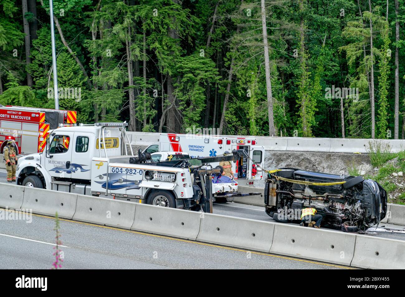 Emerncy Crews und Abschleppwagen kümmern sich um umgekippte Fahrzeug auf Highway, North Vancouver, British Columbia, Kanada Stockfoto