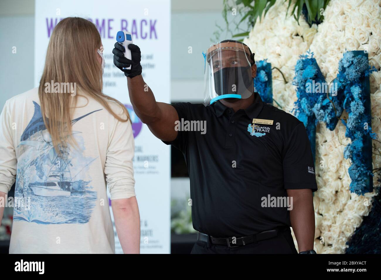 Ein Kirchenbeamter nimmt die Temperatur eines Gastes, während Tausenden eine öffentliche Betrachtung an der Brunnen des Lobes Kirche im Südwesten Houston für GEORGE FLOYD, getötet vor zwei Wochen durch einen weißen Polizeibeamten in Minneapolis, besuchen.Floyds Tod löste weltweite Proteste gegen Rassismus und Polizeibrutalität aus. Stockfoto