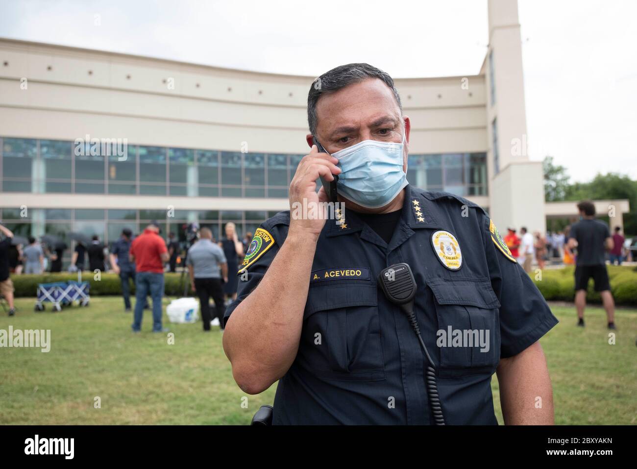 Houston Police Chief Art Acevedo nimmt einen Anruf außerhalb der Fountain of Praise Kirche, in der Tausende eine öffentliche Visitation für GEORGE FLOYD, getötet vor zwei Wochen von einem weißen Polizeibeamten in Minneapolis. Floyds Tod löste weltweite Proteste gegen Rassismus und Polizeibrutalität aus. Stockfoto