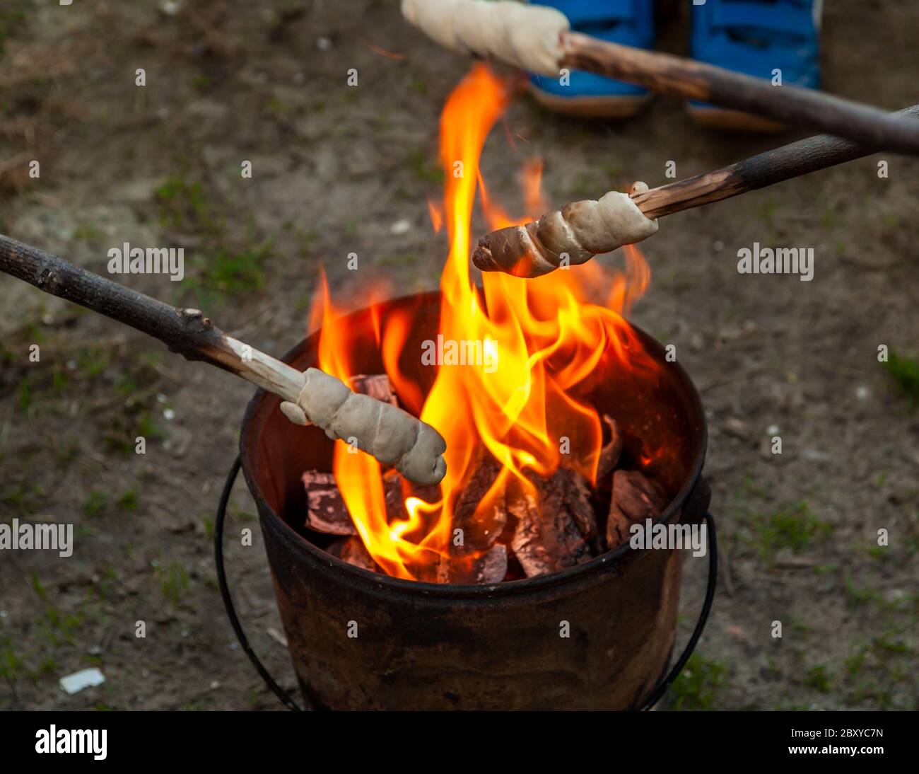 Brot auf Stöcken wird auf einem Campingplatz über einem Feuereimer gebacken. Veere-Oostkapelle, Niederlande Stockfoto