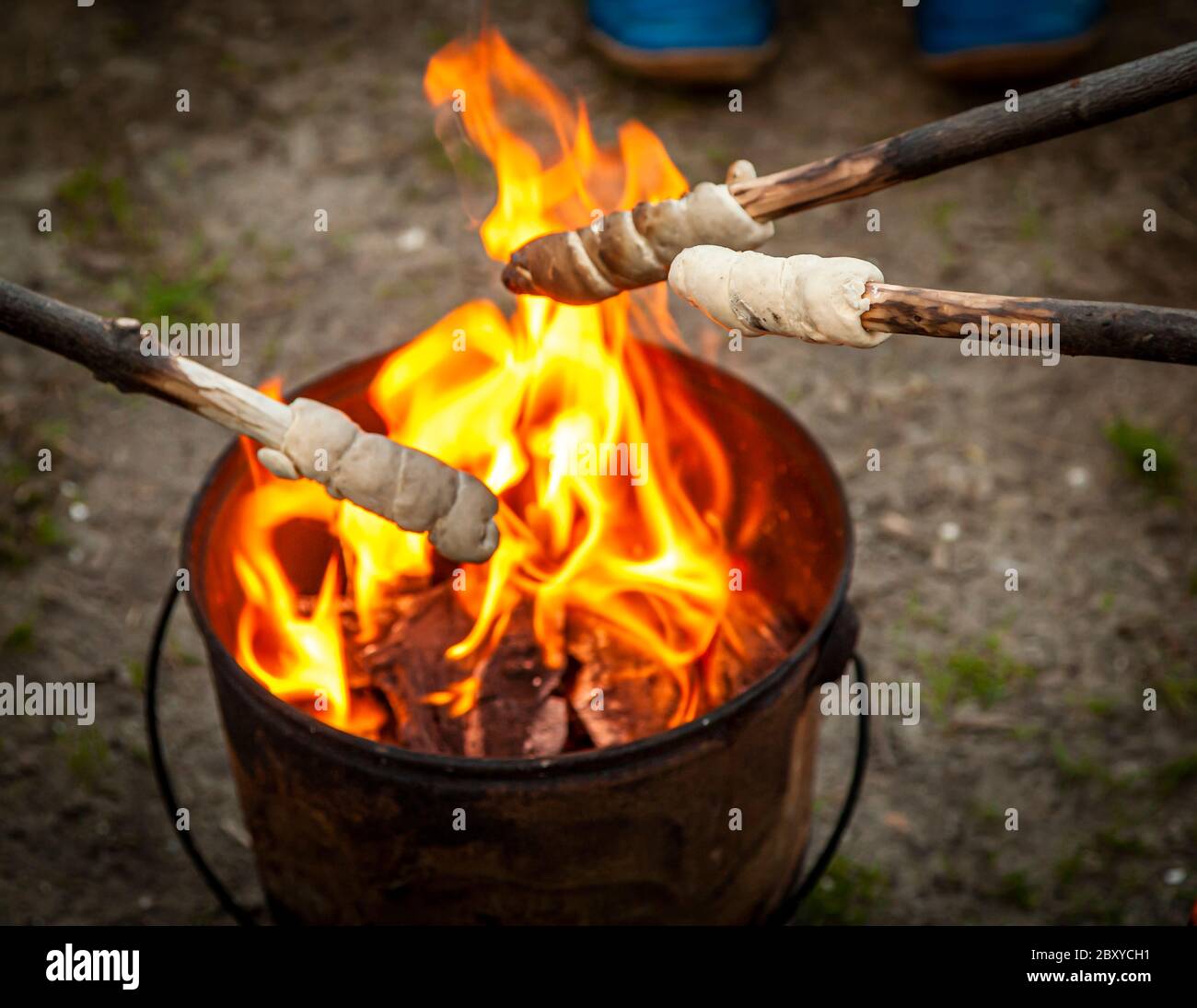 Brot auf Stöcken wird auf einem Campingplatz über einem Feuereimer gebacken. Veere-Oostkapelle, Niederlande Stockfoto