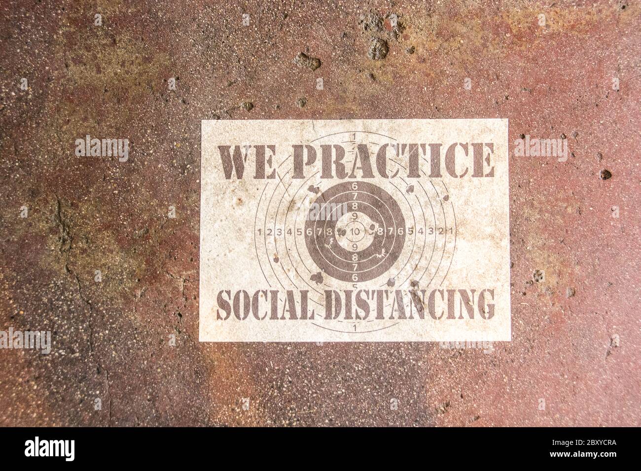 Ein Schild auf dem Boden eines Essensbetriebs mit der Aufschrift: 'Wir praktizieren soziale Distanzierung.' Stockfoto