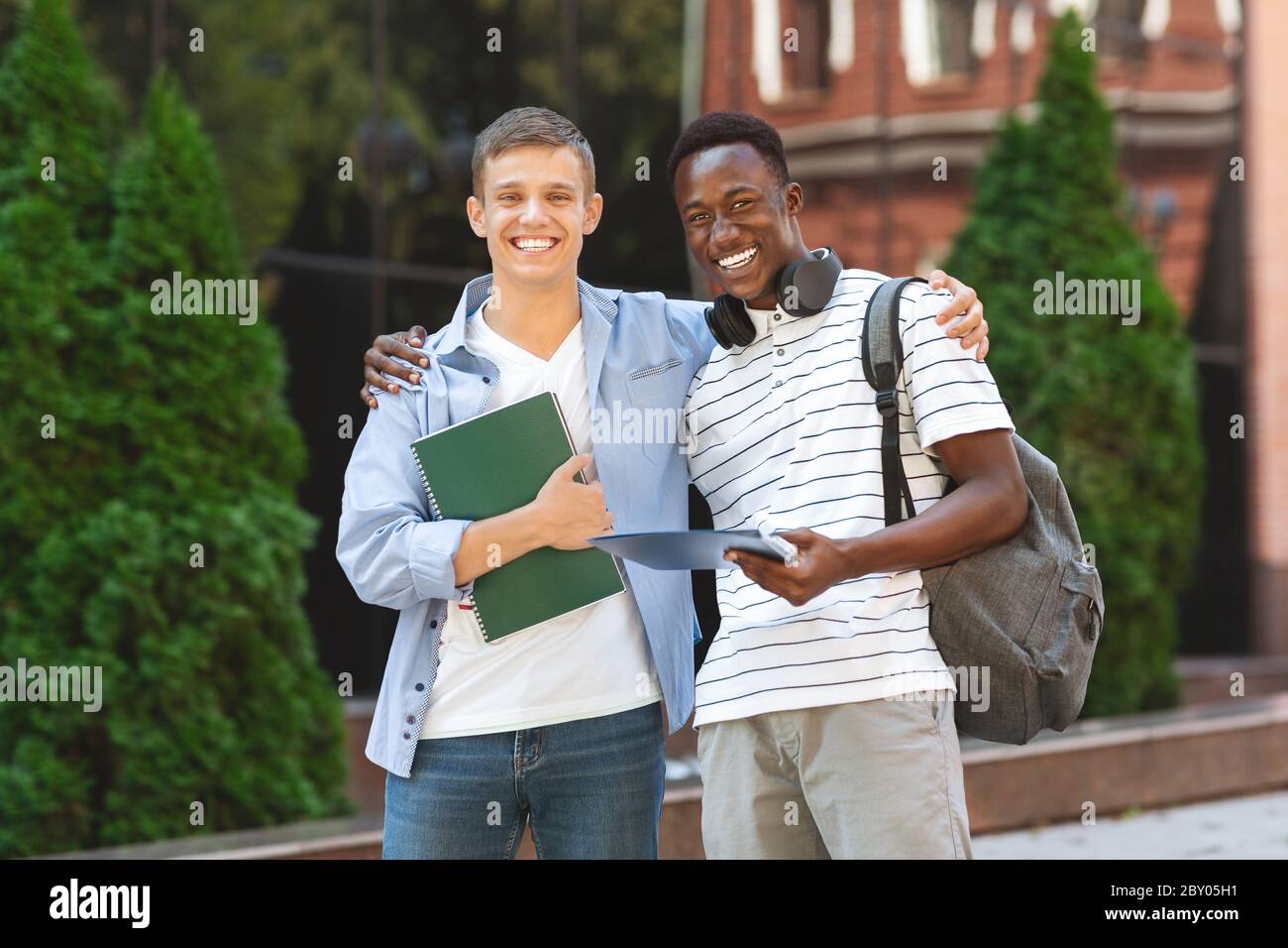 Hochschulkollegen. Zwei multiethnische männliche Studenten posieren nach dem Unterricht im Freien Stockfoto